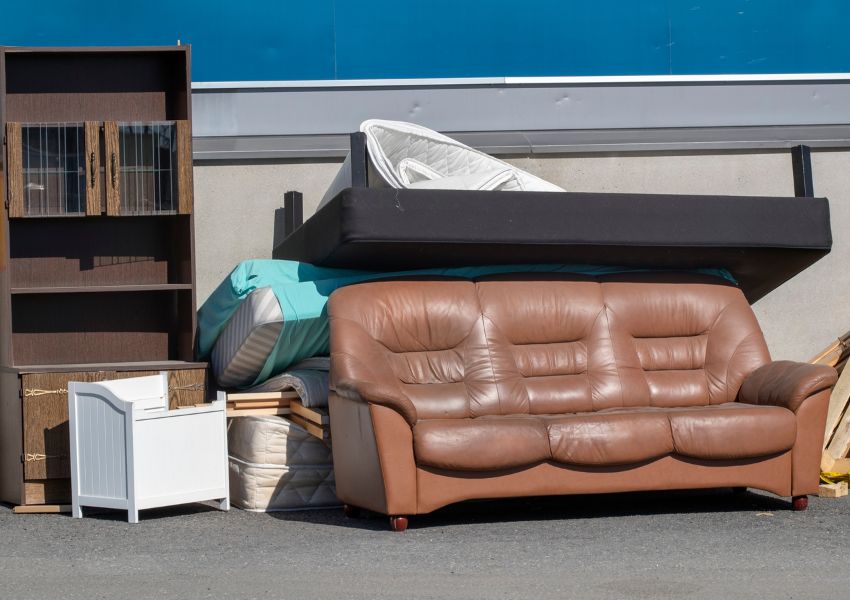 a couch, dresser and bed-frame left on the side of the road